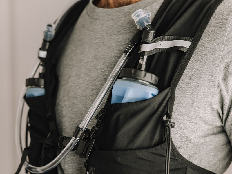 Person wearing an Everpace vest with water flasks and a bladder tube