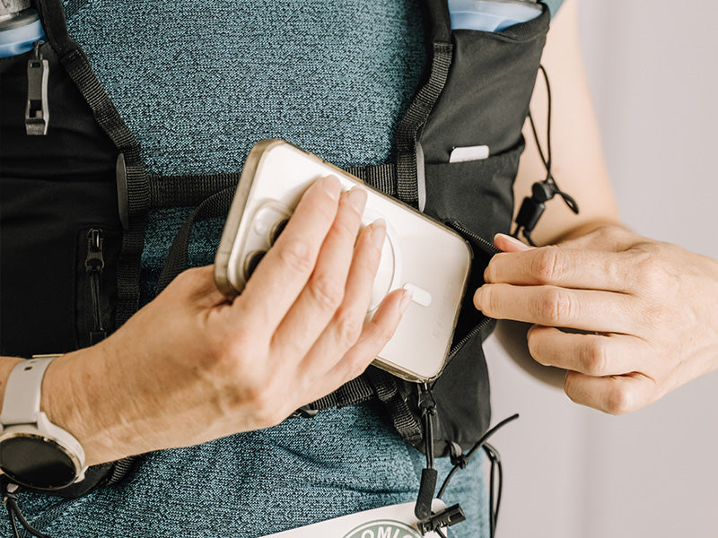 Person placing a phone into an Everpace vest pocket