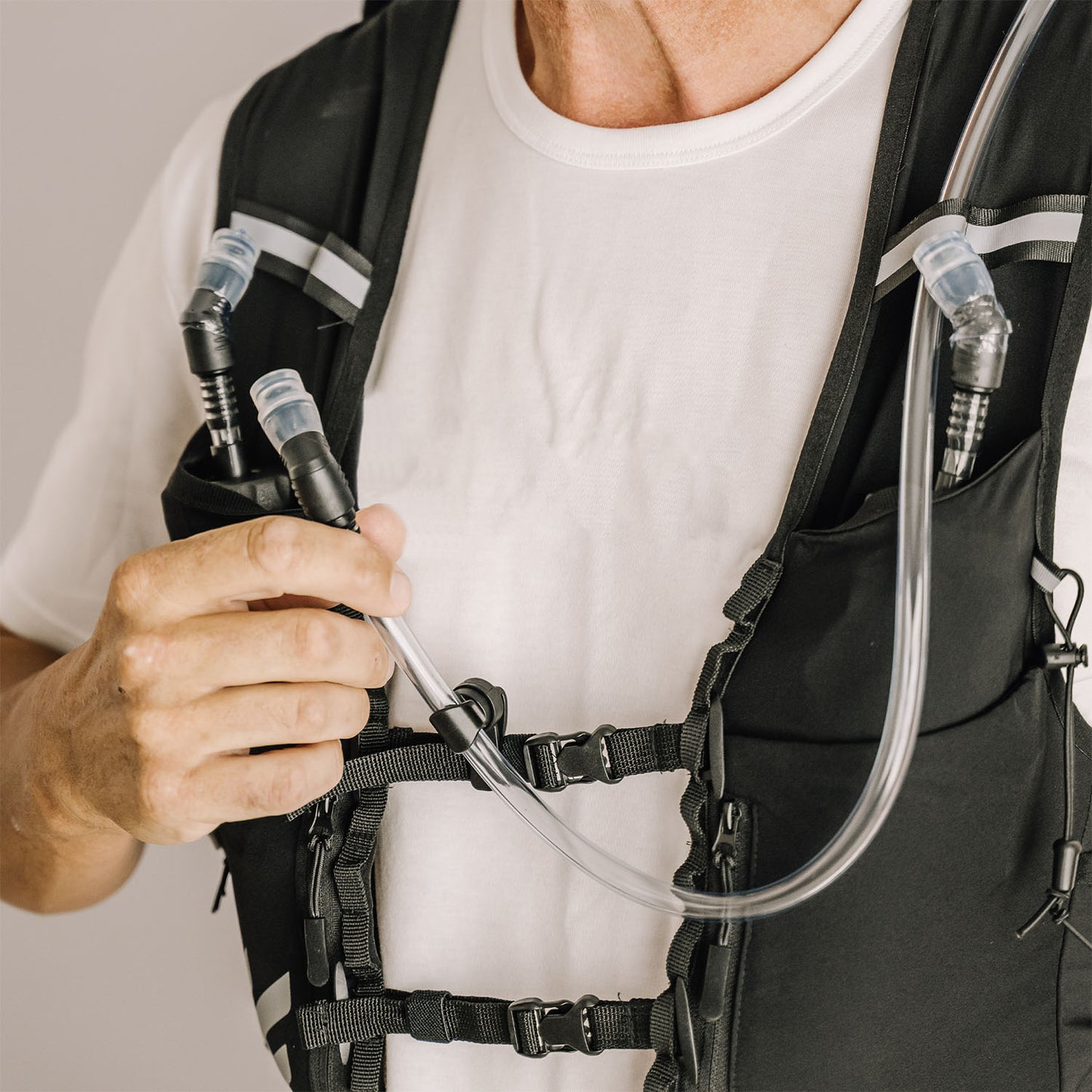 Person wearing an Everpace hydration vest with visible water flask straw and bladder tube