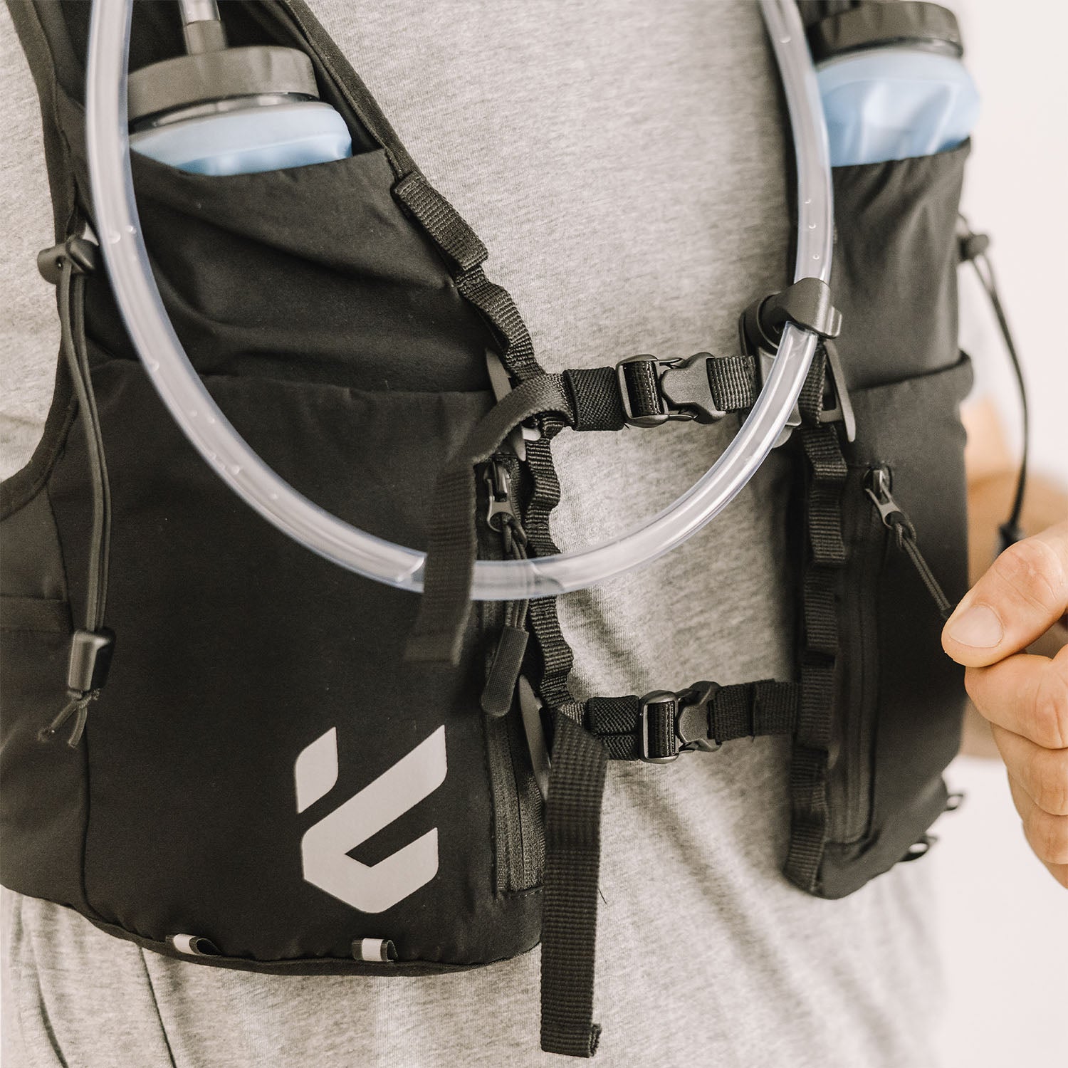 Person wearing an Everpace hydration vest and holding a zipper cord