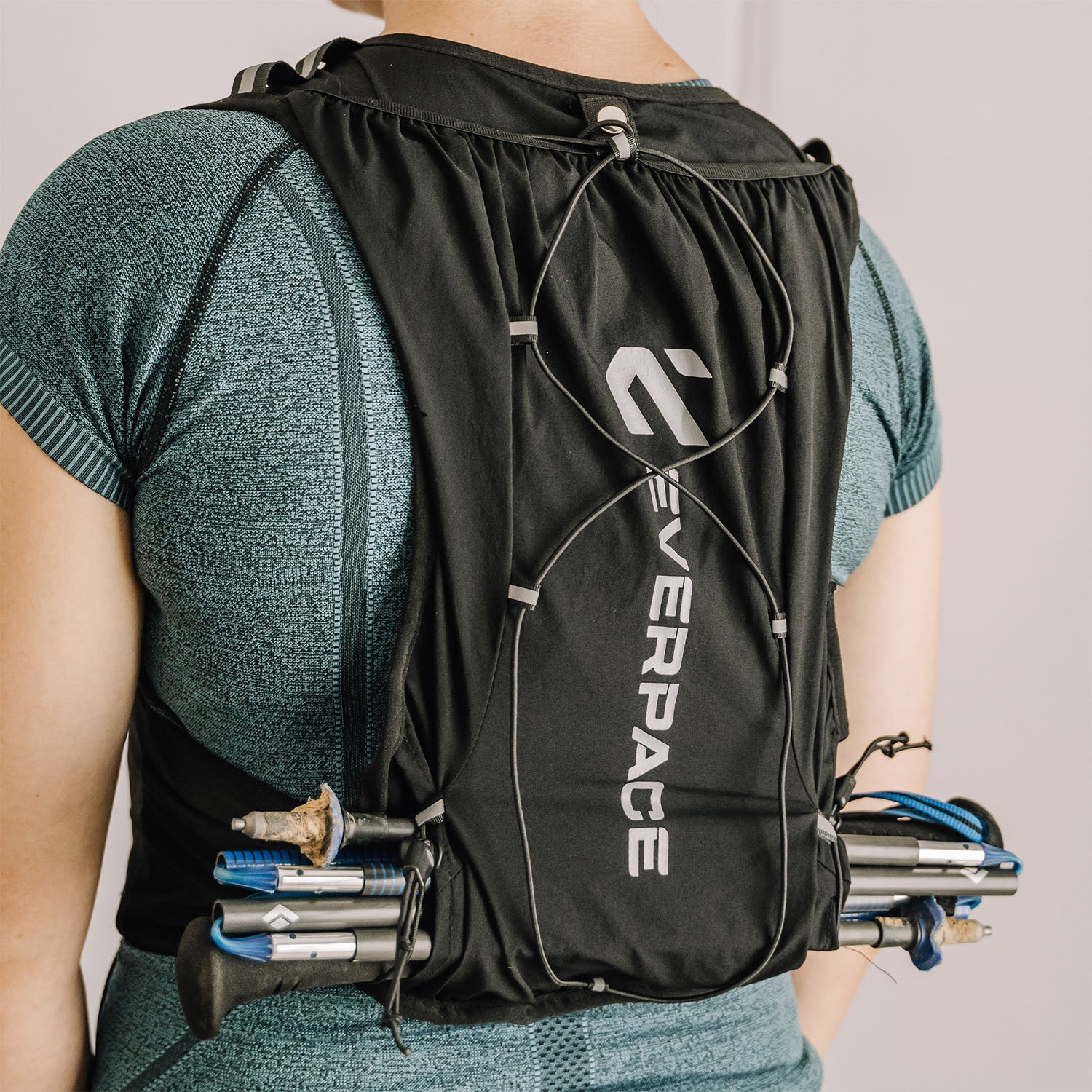 Person wearing an Everpace hydration vest, with running poles stored in the holder